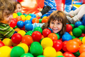 Happy playful kids enjoying while playing the the pool of balls.